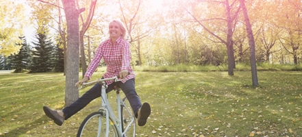 Foto di una donna in bicicletta. L’immagine illustra una donna attiva e in forma, anche durante il ciclo.